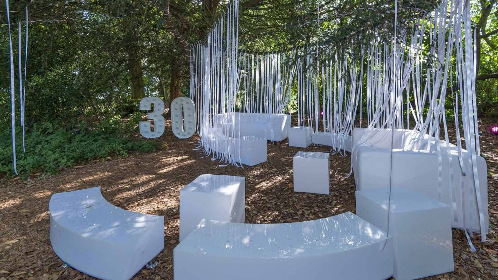 Bespoke white furniture hire and props for shill out area at festival themed 30th birthday party just outside of London