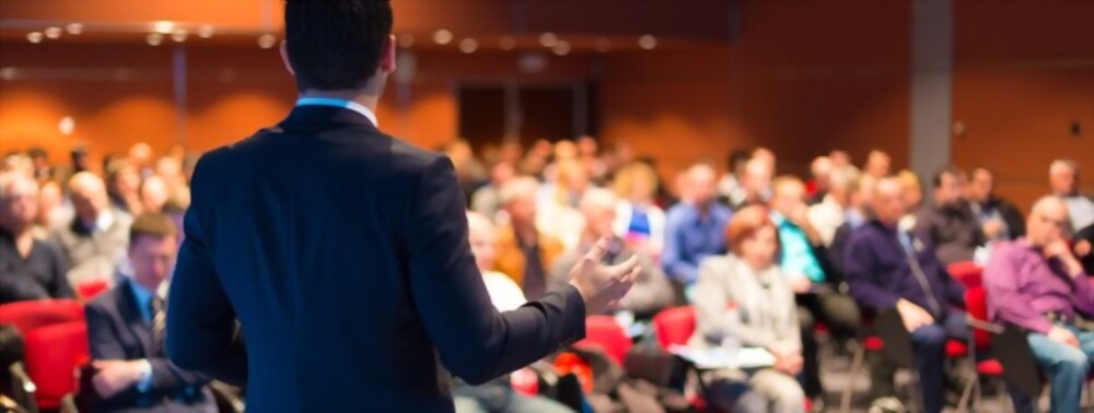 a speaker addressing an audience at a conference.