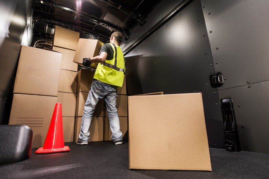 Man loading boxes in the back of a van.
