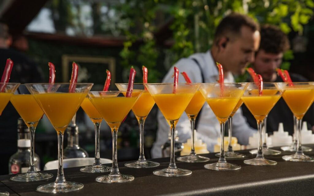 a collection of cocktail drinks on an outside bar.
