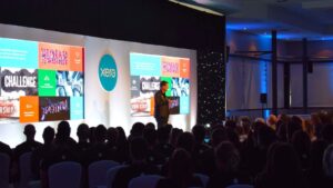 Xero conference speaker on stage watched by Xero employees.